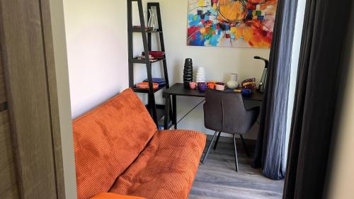 an orange chair and a desk in a room at Laumiņas in Pavasari