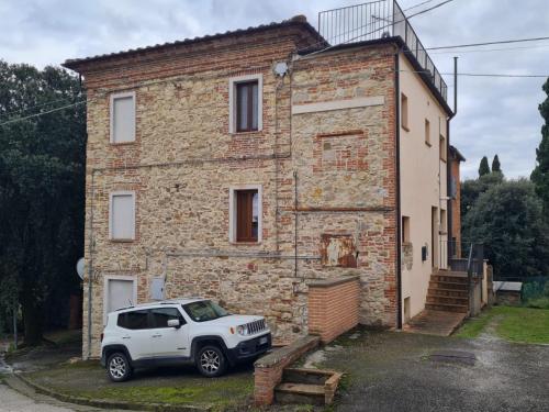 ein weißer Lastwagen, der vor einem Backsteinhaus geparkt ist in der Unterkunft Pucciarelli 1 in Castiglione del Lago