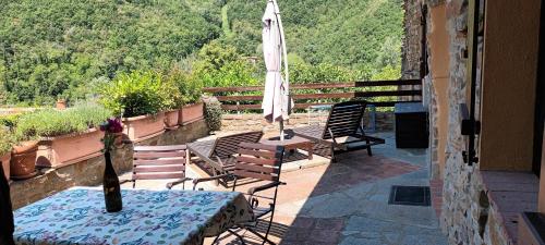 Monastero BormidaCasa Greta - Ca di Buie的带桌椅和遮阳伞的露台