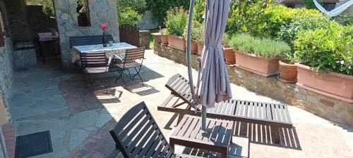 Monastero BormidaCasa Greta - Ca di Buie的天井配有桌椅和遮阳伞