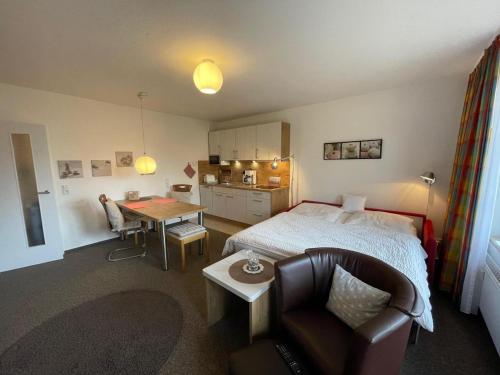 巴尔特鲁姆Dünenhus Wohnung 2的一间带床、桌子的卧室和一间厨房