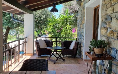eine Terrasse mit Stühlen und einem Tisch auf einem Balkon in der Unterkunft Villa Rapkinja in Mundanije