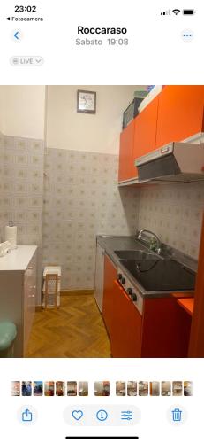 a kitchen with orange cabinets and a stove top oven at Relax House in Roccaraso