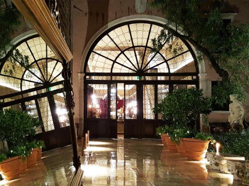 a lobby with large windows and potted plants at Palazzo Venart Luxury Hotel in Venice