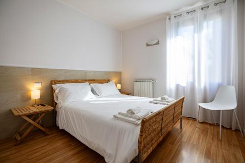 a bedroom with a large white bed and a window at Agriturismo La Corte dei Cavalieri in Montefalco