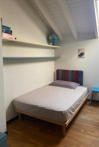 a bed in a room with shelves on the wall at Alexis 3 in Novara