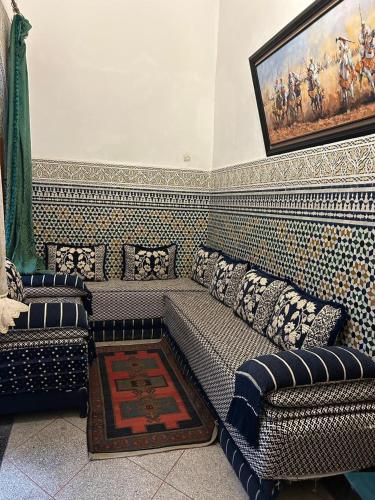a living room with couches and a painting on the wall at Maison EZ in Rabat