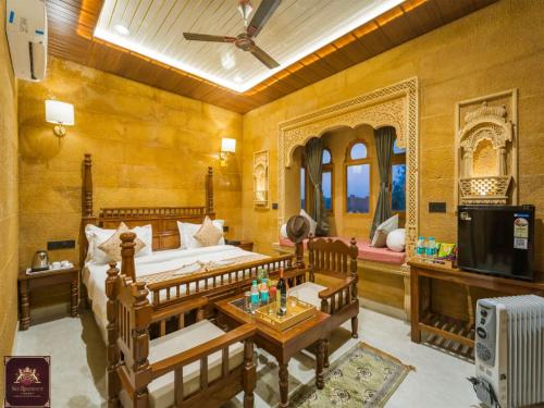 een slaapkamer met een bed, een tafel en een tv bij Sky Residency Jaisalmer in Jaisalmer
