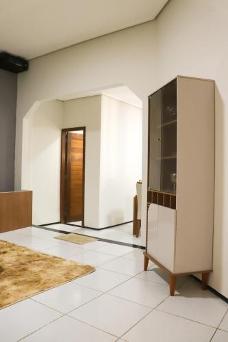 a living room with a cabinet and a door at CS1 - Ampla Casa com ArCond e Lazer Completo in Juazeiro do Norte