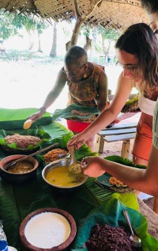 a group of people preparing food on a table at Dairy Farm Cottage Weerawila in Tissamaharama