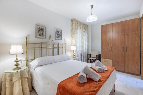 a bedroom with a large bed with towels on a bench at Inspiration and Comfort near Pts and Fermasa in Armilla