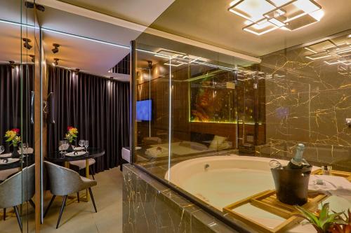 a bathroom with a tub and a table and chairs at Florence Motel Spa - Santa Rosa-RS in Santa Rosa