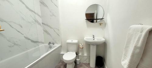 een witte badkamer met een toilet en een wastafel bij Eccles Apartment in Stirling