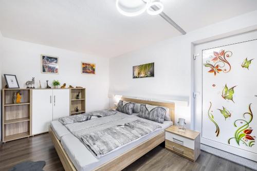 a bedroom with a bed and a wall with paintings at Leas Ferienwohnung in Aichen
