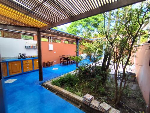 瓜拉雷马Charmosa casa na Estação Ferroviária de Luís Carlos的一栋房子的户外厨房和用餐区，铺着蓝色地板。