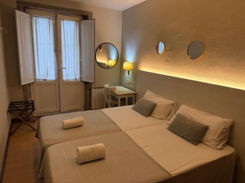 une chambre avec un lit et deux miroirs au mur dans l'établissement Hotel Real, à Saint-Jacques-de-Compostelle