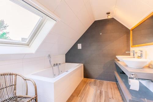 ein Badezimmer mit zwei Waschbecken und einer Badewanne in der Unterkunft Villapark Kamperfoelie 73 in De Koog