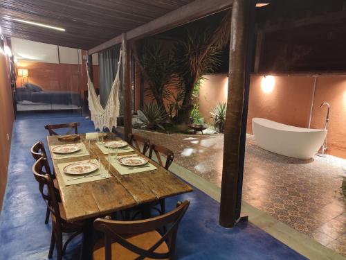 瓜拉雷马Charmosa casa na Estação Ferroviária de Luís Carlos的一间带桌子和浴缸的用餐室