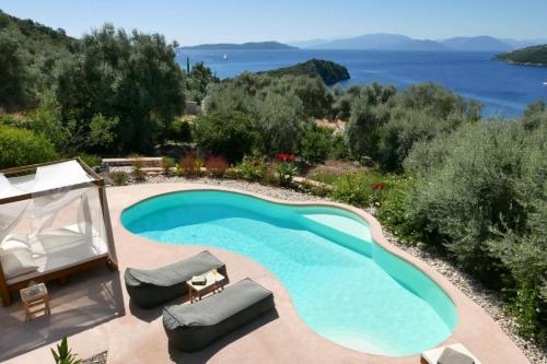 una piscina con sillas y vistas al agua en Villa Agapi Spacious Stone Retreat with Jacuzzi and Private Pool, en Sivota