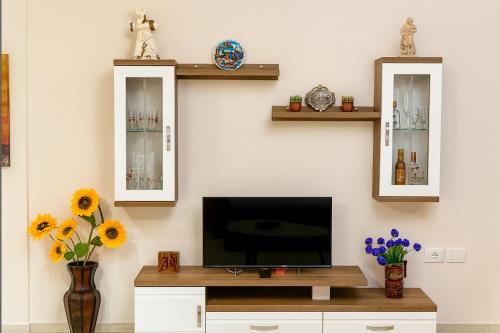 - un salon avec une télévision et deux miroirs dans l'établissement ALBis apartments 1, à Tirana