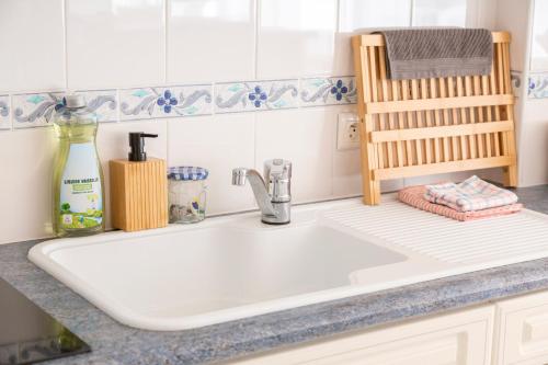 eine Küchentheke mit einer weißen Spüle in einer Küche in der Unterkunft Ty Corniche - 50m de la plage in Bénodet