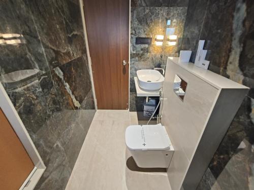een badkamer met 2 wastafels en een toilet. bij Hotel Saffron Grand Thane in Thane