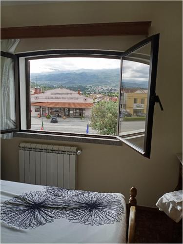 a bedroom with a window with a view of a building at Residencial Sra. da Lomba in Pinhanços