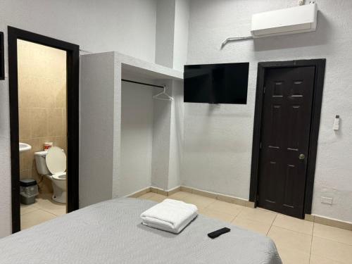 a bedroom with a flat screen tv and a bed at Apartamentos Marconela in San Mateo