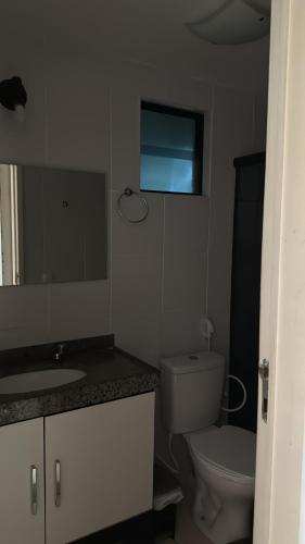 une salle de bain avec toilettes, lavabo et miroir dans l'établissement Apartamento próximo a praia, à Maceió