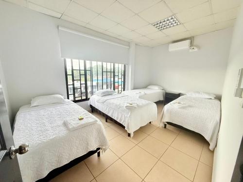 a hospital room with three beds and a window at Apartamentos Marconela in San Mateo