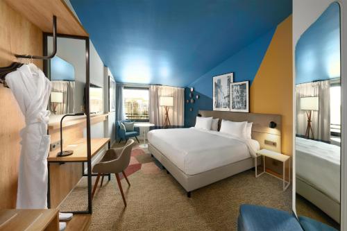 - une chambre avec un lit blanc et un plafond bleu dans l'établissement Radisson Hotel Aix En Provence, à Aix-en-Provence