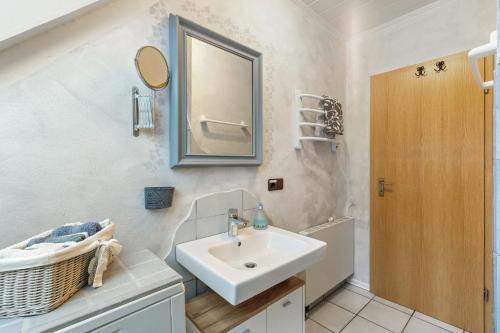a bathroom with a sink and a mirror at Ferienwohnung Am Orpeturm in Marsberg