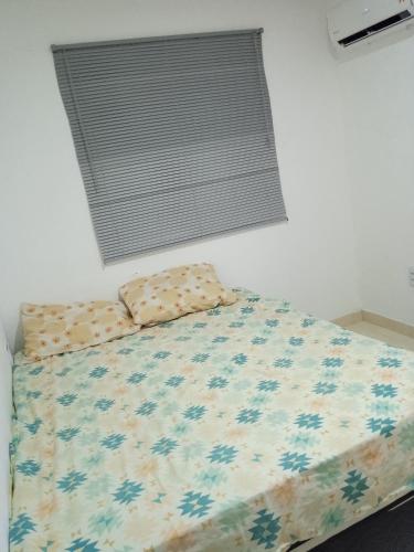 カウカイアにあるCondomínio tropicalienteのベッドルーム1室(掛け布団、枕付)