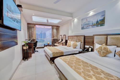 a hotel room with two beds and a flat screen tv at THE SINGH EMPIRE , Luxury collection Hotel in New Delhi