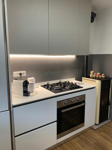 una cucina con fornelli e mobili bianchi di Casa S. Caterina a Piaia