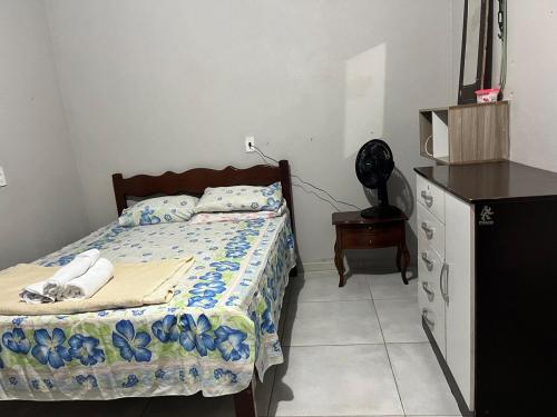 a bedroom with a bed and a dresser in it at Chalé Canto dos Pássaros in Viçosa do Ceará