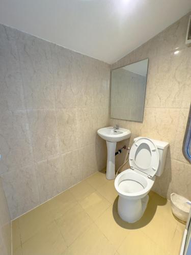 a bathroom with a toilet and a sink at Pophouse in Phetchaburi