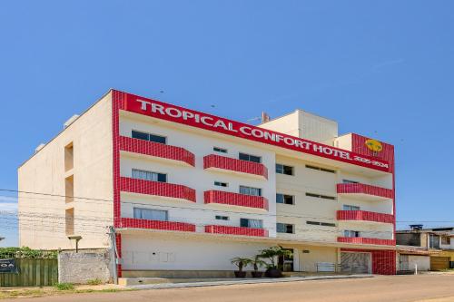 a hotel with a red sign on the side of it at OYO Tropical Confort Hotel, Brasilia in Brasília