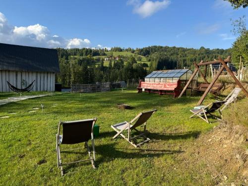 - un ensemble de chaises dans une cour avec une aire de jeux dans l'établissement Stodółka, à Nieledwia