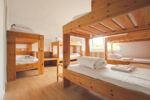 a room with three bunk beds and a window at Latas Surf House in Somo