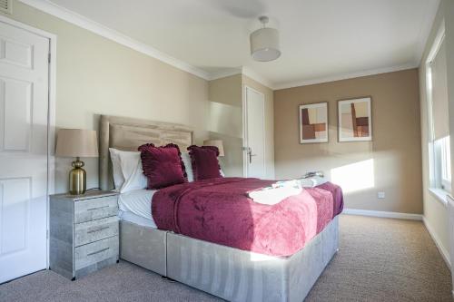 een slaapkamer met een groot bed met paarse lakens bij 4 BDR House At Caledonia Luxe Stays Short Lets & Serviced Accommodation Bo'ness in Boʼness