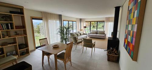 a living room with a table and chairs and a couch at Villa Maragoça Retreat Douro in Portela