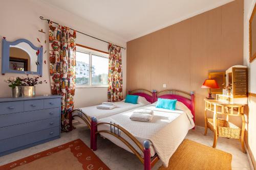 ein Schlafzimmer mit einem Bett, einer Kommode und einem Spiegel in der Unterkunft B102 - Sol Sol Lagos Apartment in Lagos