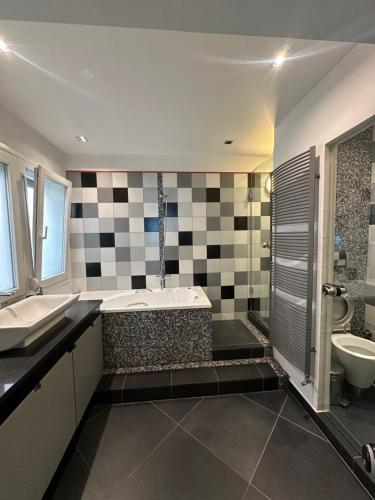 ein Badezimmer mit Badewanne, Waschbecken und Toilette in der Unterkunft Premium Seafront Suite in Thessaloniki
