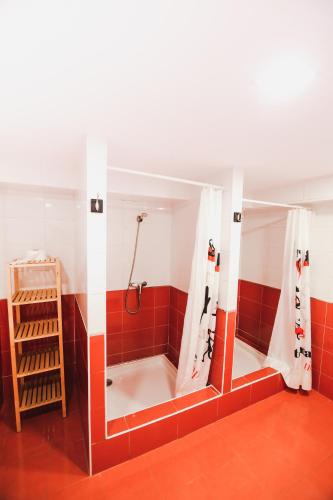 a bathroom with a shower with red tiles at Latas Surf House in Somo