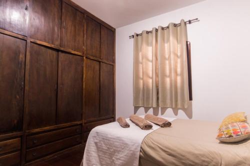 a bedroom with two beds and wooden cabinets at Villa Bem Querer - Camomila in Mairiporã