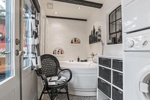 灵克宾Charming Townhouse By The Harbour的一间带椅子、浴缸和水槽的浴室