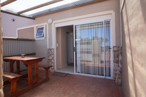 a patio with a sliding glass door with a table at Masada Guest House in Langebaan