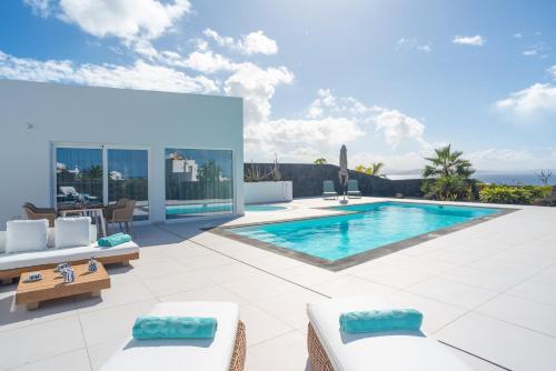 a villa with a swimming pool and a patio at Ereza Hoopoe Villas in Playa Blanca