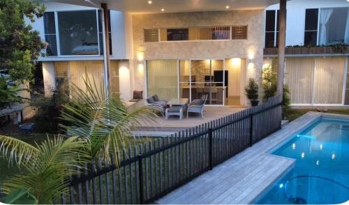 ein Haus mit einem Pool und einem Zaun in der Unterkunft Luxury Coastal Private Villa in Peregian Beach